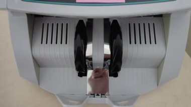 Banknotlar için sayma makinesi. Hesap makinesindeki dolarlar. Dolar banknotlarının yeniden hesaplanması. Amerikan doları banknotlar için bir makine tarafından sayılır..