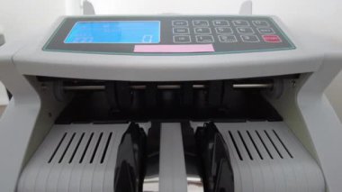Banknotlar için sayma makinesi. Hesap makinesindeki dolarlar. Dolar banknotlarının yeniden hesaplanması. Amerikan doları banknotlar için bir makine tarafından sayılır..