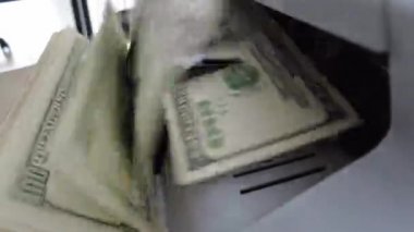 Banknotlar için sayma makinesi. Hesap makinesindeki dolarlar. Dolar banknotlarının yeniden hesaplanması. Amerikan doları banknotlar için bir makine tarafından sayılır..