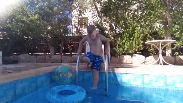ラルナカ キプロス 9月2021 子供がプールに飛び込みます プールでの夏休み 円のある少年がプールに飛び込む — ストック動画