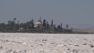Larnaca, Kıbrıs, Eylül 2021: Hala Sultan Tekke Camii bir tuz gölünün arka planında. Kurumuş tuz gölü. Dünya yüzeyindeki doğal tuz.