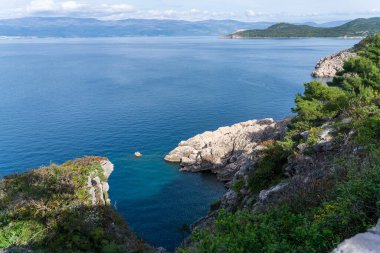 Vrbnik, Hırvatistan - 20 Nisan 2025: Dağların ve denizin panoramik manzarası. Dağların, denizin ve ormanın güzel manzarası.
