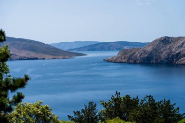 Bashka, Hırvatistan - 20 Nisan 2025: Deniz ve dağ manzaralı kasaba mezarlığı manzarası.