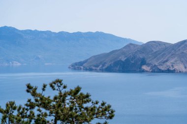 Bashka, Hırvatistan - 20 Nisan 2025: Deniz ve dağ manzaralı kasaba mezarlığı manzarası.