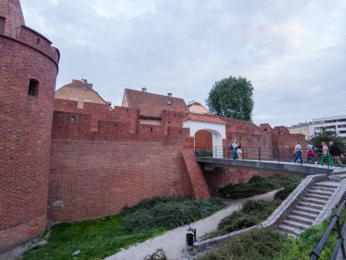 Varşova, Polonya 1 Haziran 2025: Yayalar Polonya bayraklarıyla süslenmiş tarihi Krakowskie Przedmiescie caddesi boyunca yürüyorlar, açık hava kafeleri ve Jess Hotel & Spa 'dan geçiyorlar..