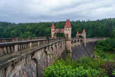 Bila Tremesna, Çek Cumhuriyeti - 27 Temmuz 2025: Elbe Nehri üzerinde peri masalı kuleleri bulunan Les Kralovstvi barajının manzarası. Tarihi mimarinin, yeşil ormanın ve taş köprünün güzel manzarası.