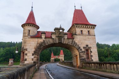 Bila Tremesna, Çek Cumhuriyeti - 27 Temmuz 2025: Elbe Nehri üzerinde peri masalı kuleleri bulunan Les Kralovstvi barajının manzarası. Tarihi mimarinin, yeşil ormanın ve taş köprünün güzel manzarası.