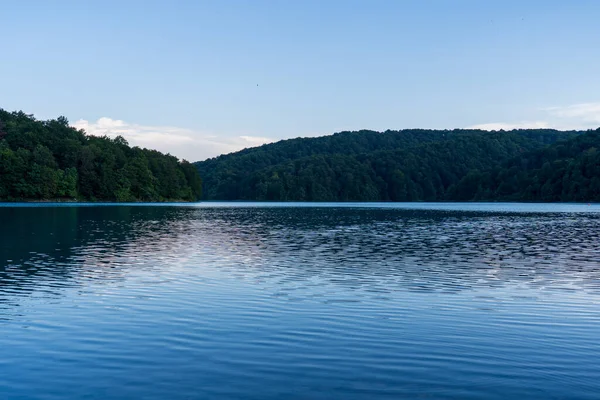 Plitvice Gölleri, Hırvatistan - 16 Ağustos 2025: Ulusal Park 'taki turkuaz göl ve şelalelerin manzaralı manzarası. Yeşillik orman ve kireçtaşı kayalıkları olan UNESCO Dünya Mirası.