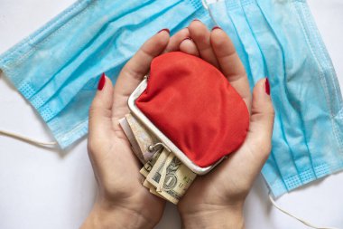 Kırmızı cüzdan, para ve Amerikan doları kürsüde tıbbi bir maskenin yanında, karantina ve finans.