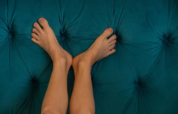 female bare feet on the bed in the bedroom ,rest on the bed