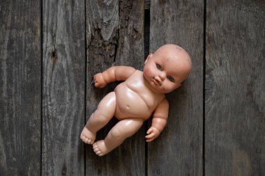 Çocukların eski plastik bebekleri yakın planda masanın üzerinde yatıyor.