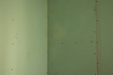 Yenileme sırasında odada yeşil alçıpan duvar, apartman yenileme, arka plan olarak alçı taşı.