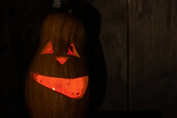 Halloween pumpkin smile and scary eyes for a party. Close up view of scary halloween pumpkin with eyes glowing inside on black background