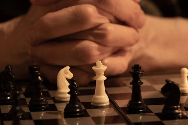 old woman\'s hand and chess in the dark, playing chess