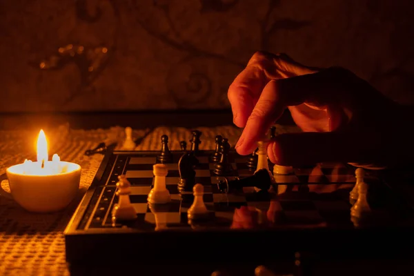 old woman\'s hand and chess in the dark, playing chess