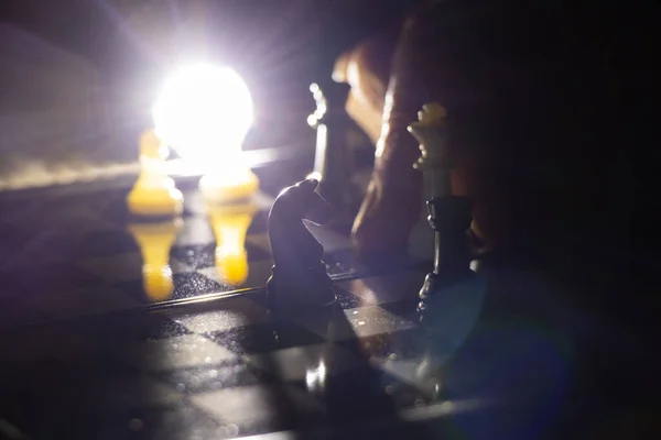 old woman\'s hand and chess in the dark, playing chess
