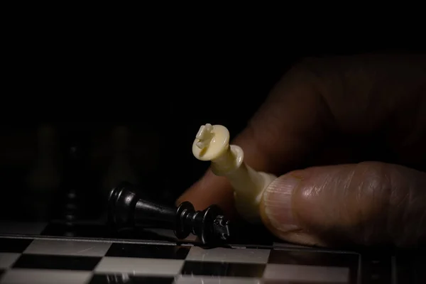 old woman\'s hand and chess in the dark, playing chess