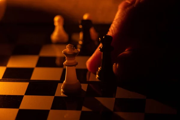 闇の中の老婦人の手とチェス — ストック写真