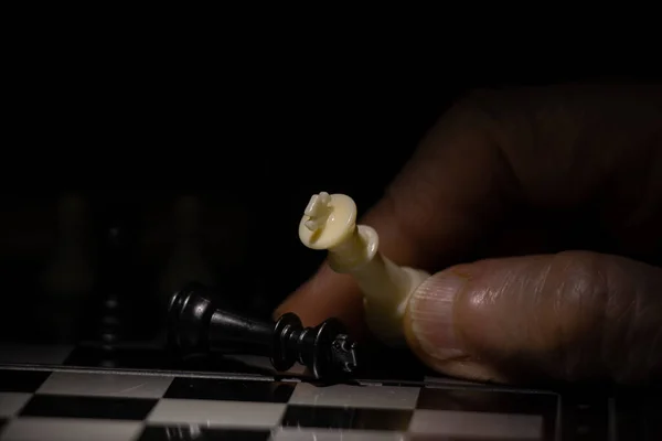 闇の中の老婦人の手とチェス — ストック写真