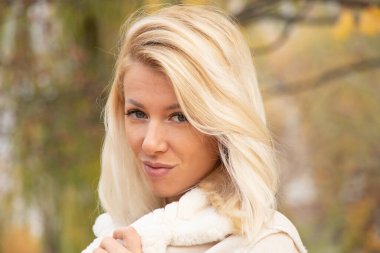 Sonbahar öğleden sonra parkta sarışın genç bir kızın portresi.