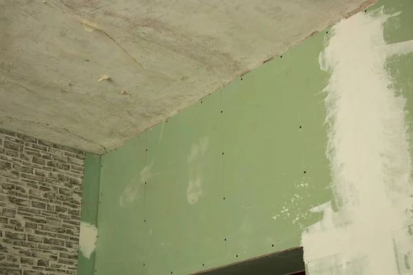 green drywall wall in the room during renovation, apartment renovation, gypsum plasterboard as a background