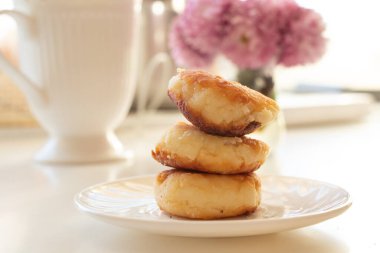 Sabah kahvaltısı için süzme peynirli krep. Mutfaktaki bir tabakta güneşli bir masada yatıyor.