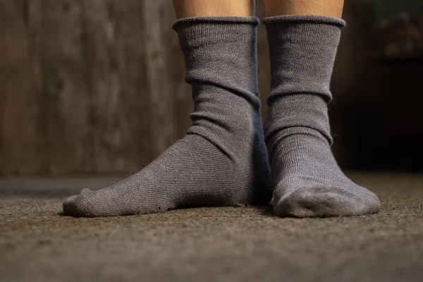 Mavi çoraplı ayaklar, gri bir halı, bir apartman dairesi, evde bir gün tatil.
