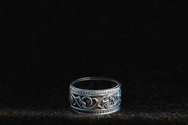Okrągły samiec srebrny pierścień na czarnym tle w neonowym świetle zbliżenie — Zdjęcie stockowe