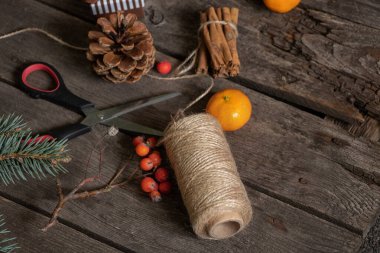 Yeni yıl dekorasyonu için atölyedeki çalışma masasında makas tarçın çam ağacı konisi, yeni yıl dekorasyonu.