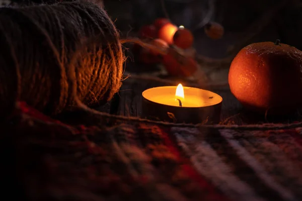 木の上の糸とみかんの皮の横にあるキャンドル新年のテーブルの装飾 — ストック写真