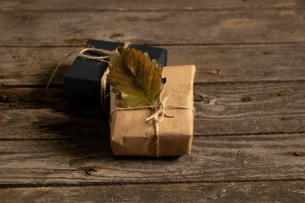 Noel hediye kutuları kağıt iplik ve ahşap bir arka planda el yapımı Noel dekoru, hediye kutusu