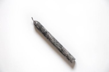 Beyaz arka planda bir siyah mum. Yakın plan.