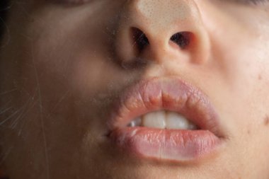 Genç seksi kız sisli bardağı öpüyor.