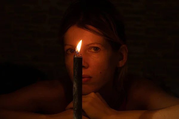 Lány Arca Sötétben Egy Fekete Égő Gyertya Hátterében — Stock Fotó