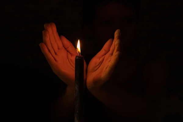 Mano Nel Buio Vicino Alla Fiamma Una Candela Nera Vicino — Foto Stock