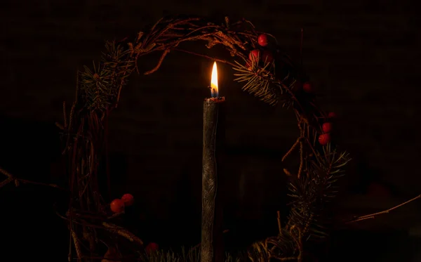 在新年的松木花环的背景上燃着蜡烛 夜晚的背景是漆黑的 — 图库照片