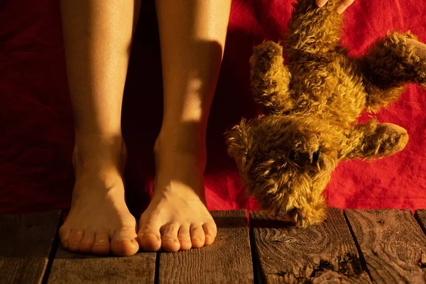 Piedi Femminili Sul Pavimento Accanto Orsacchiotto Buio Con Una Lampada — Foto Stock