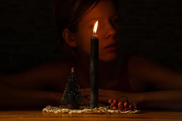 Egy Lány Egy Asztalnál Egy Gyertya Mellett Egy Kis Karácsonyfa — Stock Fotó