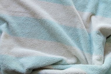 Duş almak için beyaz-mavi bir şeritte çizgili havlu.