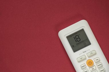 Kadın el düğmesi, izole edilmiş arkaplanda, beyaz klimanın uzaktan kumandasında.