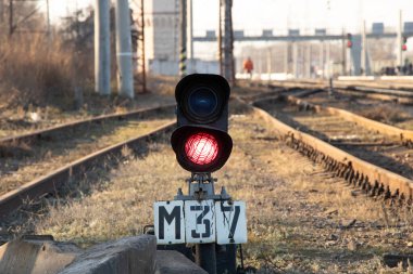 old railway traffic light with red light on on the railroad in the afternoon in Ukraine clipart