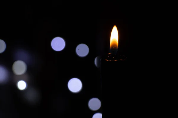 Świeca Płomień Ciemności Tle Rozmazane Girlandy Bokeh Religia — Zdjęcie stockowe