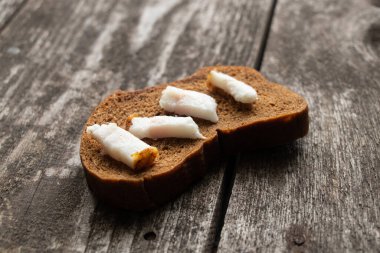 Öğle yemeği için ahşap bir masada pastırmalı siyah ekmek dilimi.