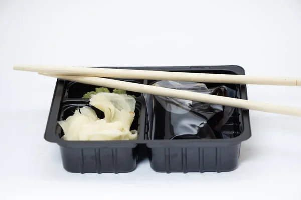 plastic food container with sushi from restaurant on isolated background, takeaway food order