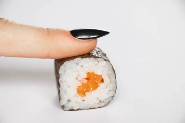 搭配鲑鱼的寿司是由一位女性手拿着白底特写的餐馆食物 — 图库照片