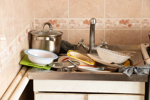 Evdeki mutfaktaki lavaboda bulaşık yığını var.
