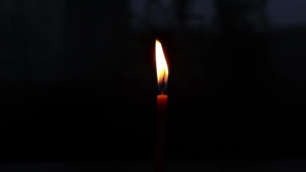 De vlam van één brandende kaars in de donkere close-up — Stockvideo