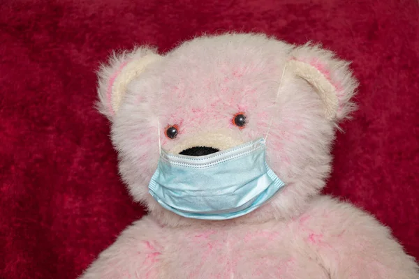 Baby Roze Teddybeer Een Medisch Masker Een Rode Achtergrond Quarantaine — Stockfoto