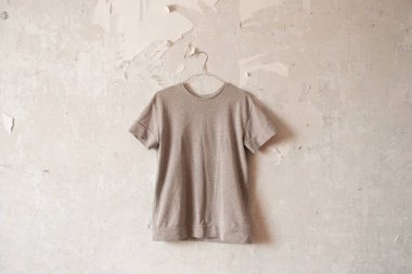 Beyaz bir duvarda asılı asılı kadın gri ceketi.