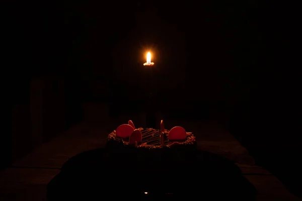 在黑暗中点着一支蜡烛的生日蛋糕 — 图库照片